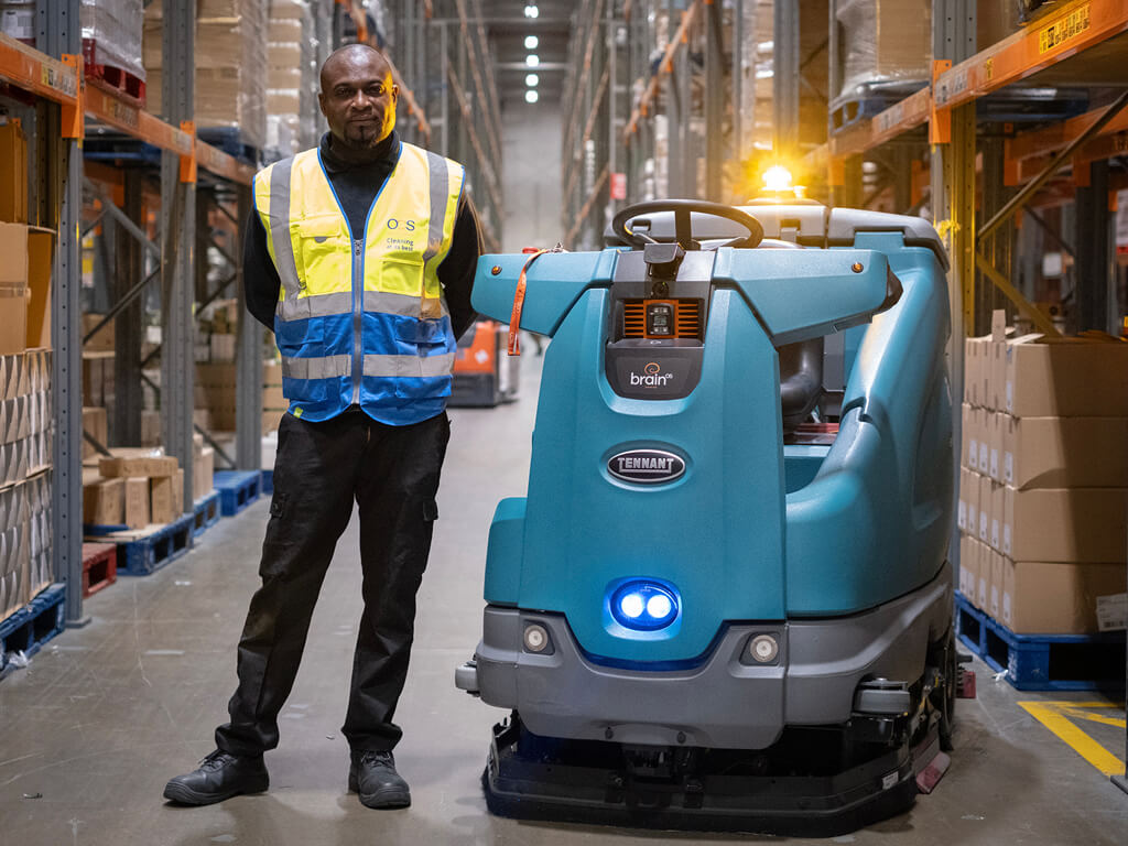 OCS cleaning robot in warehouse alongside cleaner