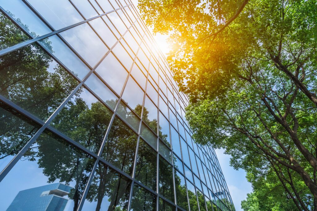 A government building surrounded by trees, with sunlight streaming through its glass facade, highlighting capital projects.