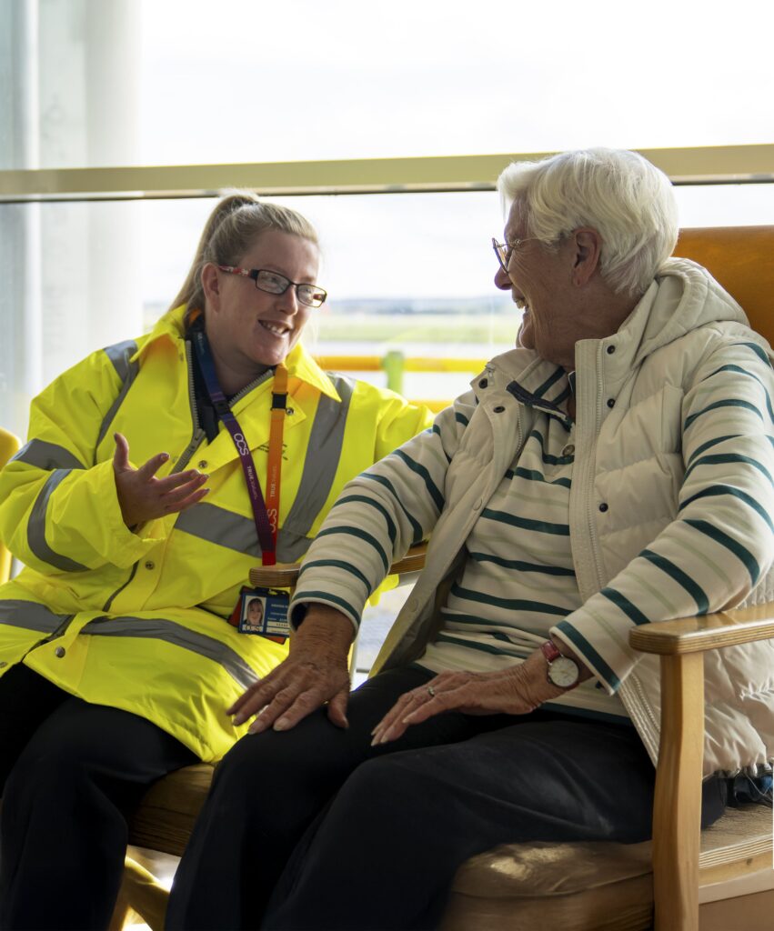 A female OCS passenger services colleague is dressed in a bright yellow jacket, showcasing her role and commitment.