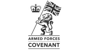 Logo shows a lion holding a Union Jack flag, with a crown above. Below, text reads Armed Forces Covenant. The design uses black and white lines on a plain background.