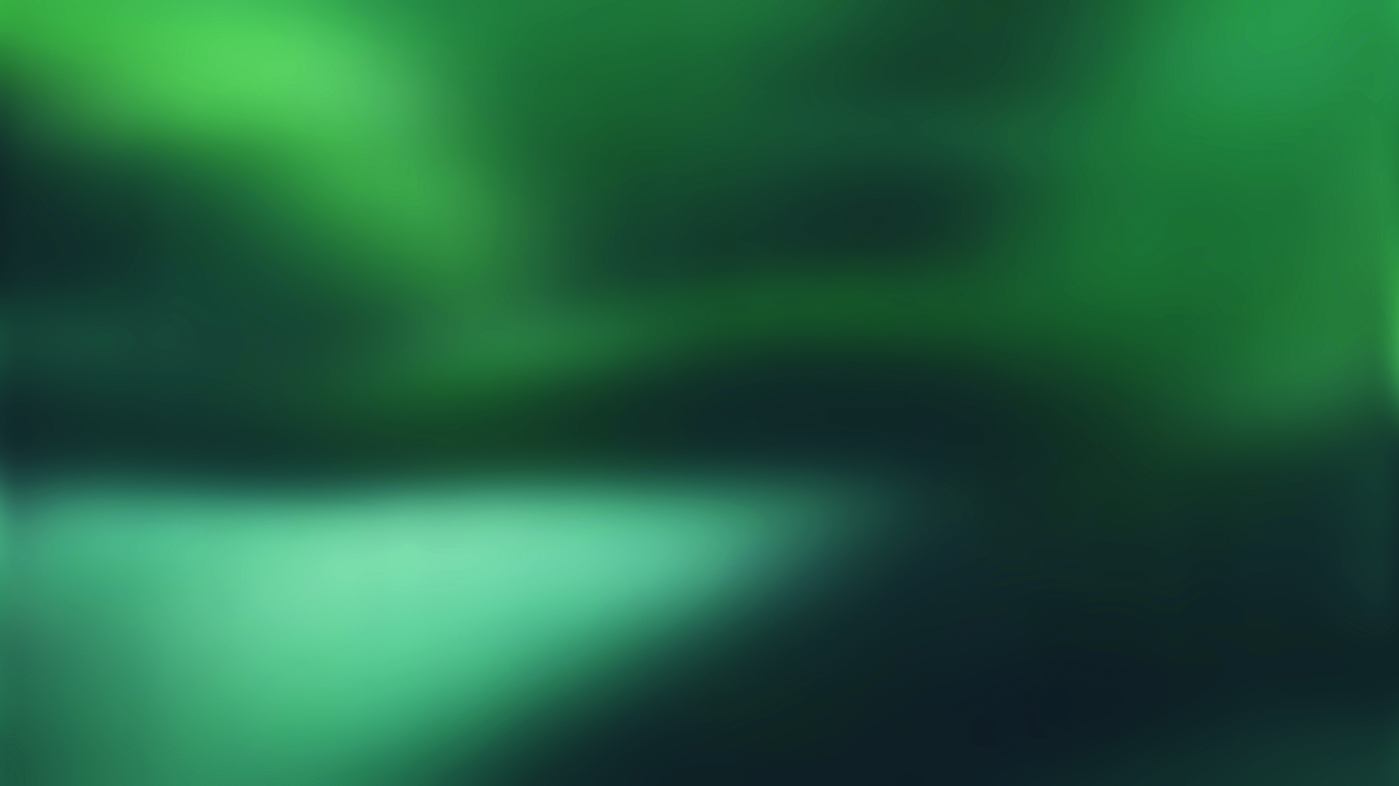 A blurry image with gradients of green and teal colours blending together, creating an abstract and soft visual effect.