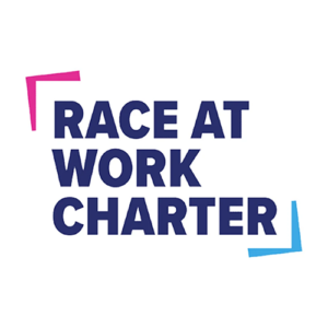 The image features the words Race at Work Charter in bold, dark blue text, framed by a pink angle in the top left corner and a blue angle in the bottom right corner, on a white background.