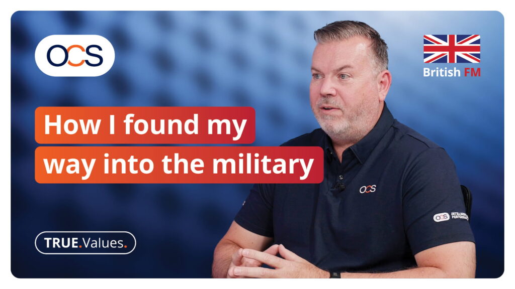 A man in a polo shirt speaks during a video titled How I found my way into the military, featuring the OCS logo and a British FM flag icon.