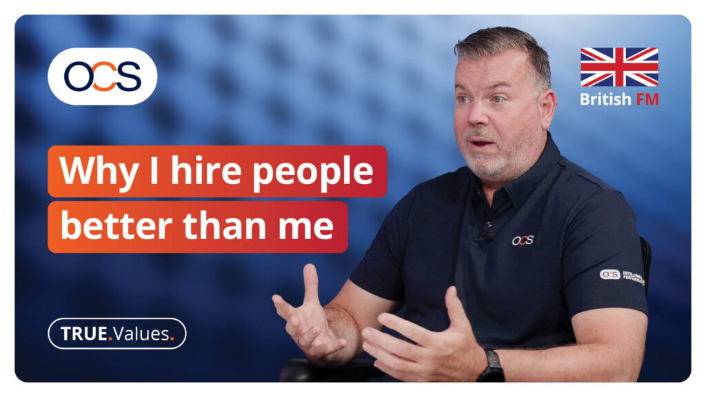 A middle-aged man speaks whilst gesturing, set against a blue background with the text Why I hire people better than me, the OCS logo, and a British flag.